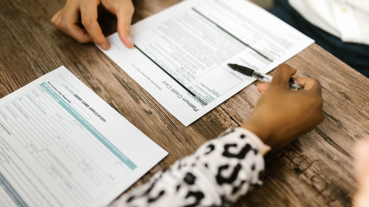 Paar sitzt am Tisch und prüft Kreditunterlagen mit Taschenrechner