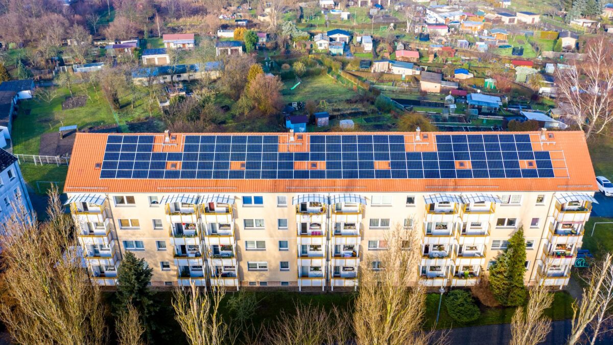 Aerial view of apartment complex with solar panels on rooftop in Beeskow, Germany.