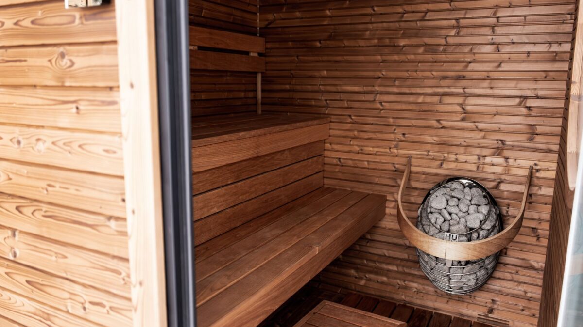 Explore a serene wooden sauna featuring Nordic design and modern electric heater for ultimate relaxation.