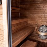 Explore a serene wooden sauna featuring Nordic design and modern electric heater for ultimate relaxation.