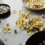 A close-up of assorted pills and supplements arranged on a marble surface, highlighting healthcare and wellness themes.