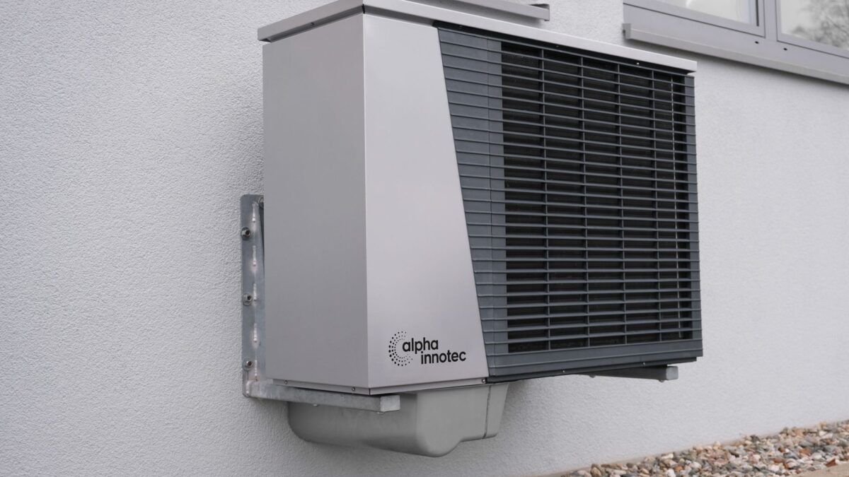 Outdoor air conditioning unit mounted on a residential building exterior.