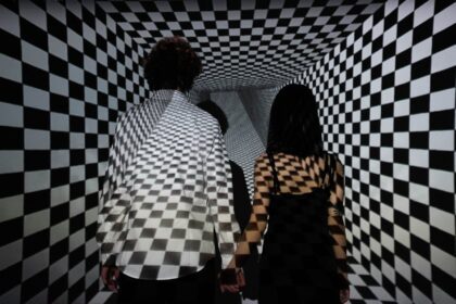 illuseum berlin - Couple walking in a checkerboard tunnel, creating an optical illusion of depth and