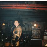 sid vicious - Tattooed female punk singer performing energetically on stage at a concert.