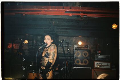 sid vicious - Tattooed female punk singer performing energetically on stage at a concert.