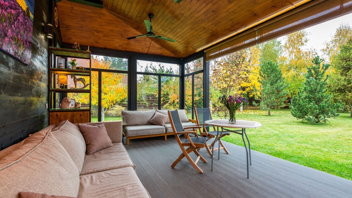 Überdachte Terrasse mit Holzkonstruktion an einem Wohnhaus im Herbst